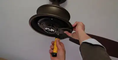 Electrician installing ceiling fan mounting bracket and fixture in St Paul, MN