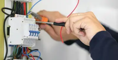 Electrician installing and adjusting circuit breakers in an electrical panel in St Paul, MN