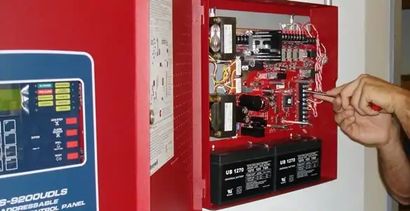 fire alarm installation service showing technician configuring fire alarm control panel in St Paul, MN