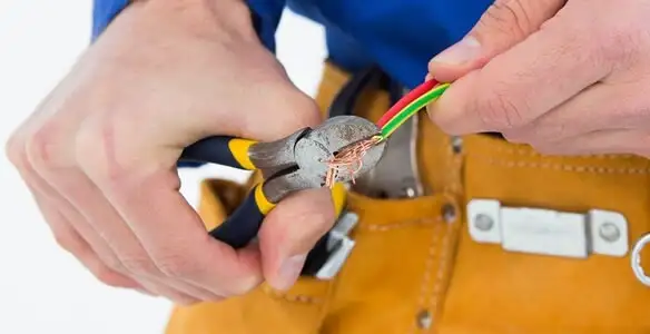 licensed electrician securing electrical wiring with professional tools during service work in St Paul, MN