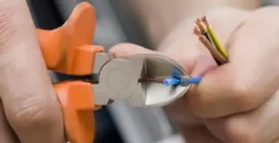 licensed electrician performing precise wire cutting and preparation during electrical service in St Paul, MN