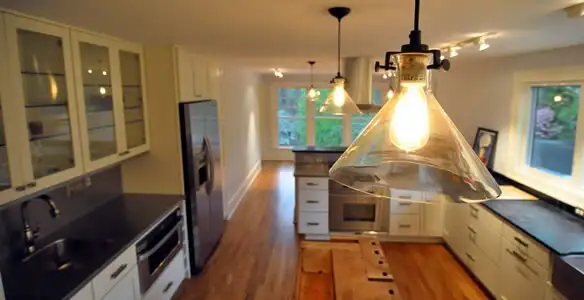 Residential electrician installing modern indoor light fixture in a home in St Paul, MN