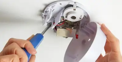 Certified technician wiring smoke detector during installation in St Paul, MN